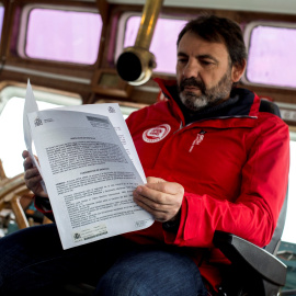 El fundador de la ONG Open Arms, Oscar Camps , lee el despacho enviado por el Ministerio de Fomento, que les deniega el permiso para zarpar hacia el Mediterráneo.EFE/ Quique García