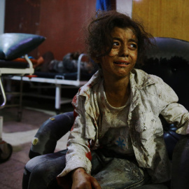 Una niña siria llora en un hospital improvisado en la zona controlada por los rebeldes en Douma, al este de Damasco, tras los ataques aéreos por las fuerzas del régimen, el 12 de agosto de 2015. AFP PHOTO / ABD DOUMANY