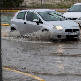 Vehículos circulando por una rotonda anegada en Espartinas (Sevilla). - EFE