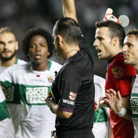Los jugadores del Elche protestan ante el árbitro Muñiz Fernández por un penaly en contra del equipo. EFE