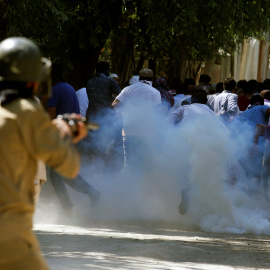 Manifestantes huyen ante un policía que dispara gases lacrimógenos durante una manifestación contra los recientes asesinatos en Cachemira, en las afueras de Srinagar. REUTERS/Danish Ismail