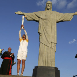 La jugadora de voleibol Isabel Barroso levanta la antorcha ante el Cristo Redentor. /REUTERS