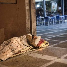 Un hombre durmiendo en un el suelo de la calle. EFE