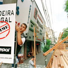 Un activista coloca un cartel que denuncia la extracción ilegal de madera en el Amazonas. AFP/MARIE HIPPENMEYER