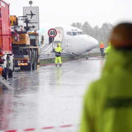 Varios operarios acondicionan una carretera después de que un avión de carga de la compañía DHL se saliera de la pista tras aterrizar la pasada madrugada en el aeropuerto italiano de Bergamo . EFE/Matteo Bazzi
