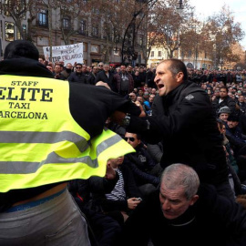 Dos taxistas se encaran durante la asamblea que han celebrado este sábado en Barcelona. (TONI ALBIR | EFE)