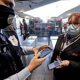 Un guardia de seguridad comprueba el certificado covid de una trabajora municipal en Nápoles (Italia).