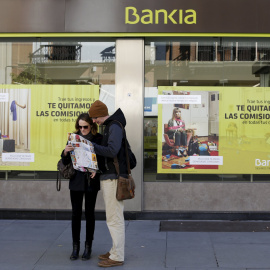 Dos turistas consultan un mapa frente a una oficina de Bankia en Sevilla. REUTERS/Marcelo del Pozo