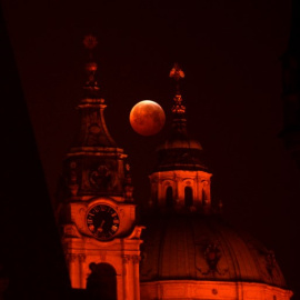 La luna de sangre vista entre la iglesia de San Nicolás, en Praga, República Checa. Michal CIZEK / AFP