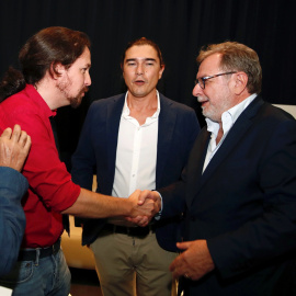 25/09/2019.- El líder de Podemos, Pablo Iglesias (i) saluda al periodista y miembro de la RAE Juan Luis Cebrián (d) junto al autor, Daniel Serrano, durante la presentación de la obra 'Cal viva'. / EFE - JAVIER LÓPEZ