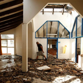 Un operario municipal revisa el estado de una escuela de primaria tras el incendio registrado en la localidad de Vitrolles, cerca de Marsella, en el sur de Francia. Varios incendios ayudados por los fuertes vientos amenazan Marsella, donde 