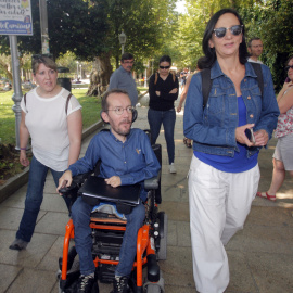 El secretario de Organización de Podemos, Pablo Echenique (c), junto a la secretaria de Análisis Político y Social, Carolina Bescansa (d), pasea por Santiago de Compostela tras la rueda de prensa sobre  las negociaciones con En Marea para l