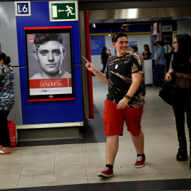 Gabriel Díaz de Tudanca le enseña a una amiga la campaña de concienciación en la que participó para el Ayuntamiento de Madrid. / REUTERS - SUSANA VERA