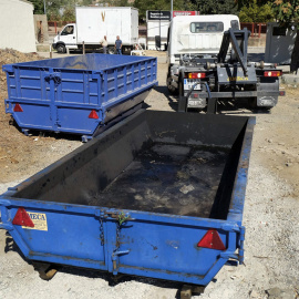 Una grúa se dispone a retirar el contenedor de residuos, donde fue encontrado el cadáver calcinado de una mujer de raza negra.- EFE