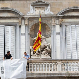 El moment en què personal de la Generalitat retira la pancarta amb el llaç groc. EUROPA PRESS / AVID ZORRAKINO