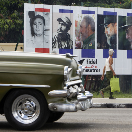 Un vehículo pasa en La Habana junto a un cartel alusivo al cumpleaños 90 del líder de la revolución cubana Fidel Castro. EFE/Ernesto Mastrascusa