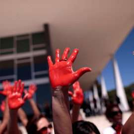 Manifestantes levantan sus manos teñidas de rojo en una manifestación en Braslia contra las violaciones. REUTERS