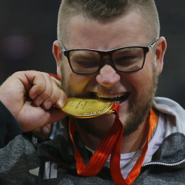 Pawel Fajdek muerde la medalla de oro lograda en lanzamiento de martillo. /REUTERS