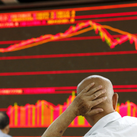 Un hombre contempla los índices bursátiles en la Bolsa de Pekín. REUTERS