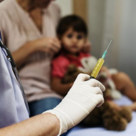 Un médico prepara una dosis de una vacuna.