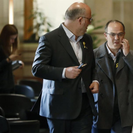 El diputado de Junts per Catalunya, Jordi Turull (i), junto al portavoz parlamentario del grupo, Eduard Pujol (d), en los pasillos del Parlament. /EFE