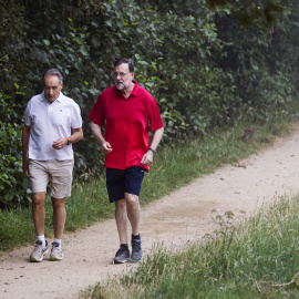 El presidente del Gobierno en funciones, Mariano Rajoy, acompañado de José Benito Suárez, presidente de la Autoridad Portuaria de Marín y marido de la presidenta del Congreso, Ana Pastor, en su paseo matutino por la Ruta del Agua y la Piedr