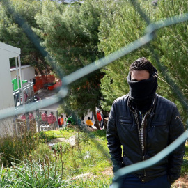 Un migrante tapa su rostro mientras aguarda en el Centro de Recepción de Inmigrantes de Lampedusa.- AFP
