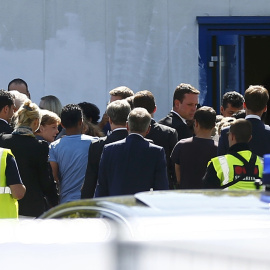 La canciller Angela Merkel, rodeada de refugiados sirios durante su visita al atacado centro de acogida de refugiados en Heidenau, al este de Alemania.- REUTERS