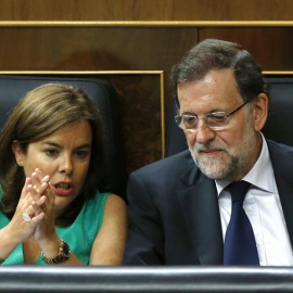 El presidente del Gobierno, Mariano Rajoy (d), y la vicepresidenta, Soraya Sáenz de Santamaría (i), conversan durante el segundo día del debate de totalidad del proyecto de Ley de Presupuestos para 2016, en el pleno del Congreso. EFE/Sergio