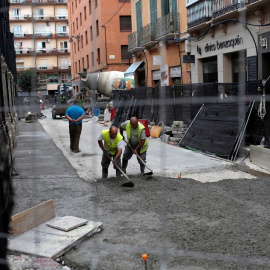Dos hombres asfaltan una calle en Málaga/REUTERS