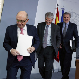 El ministro de Hacienda, Cristóbal Montoro, seguido por el de Exteriores, Alfonso Dastis, y el  portavoz del Gobierno y ministro de Educación, Íñigo Méndez de Vigo, al finalizar la rueda de prensa posterior a la reunión del Consejo de minis