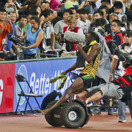 Bolt es arrollado por un cámara durante su celebración.-REUTERS