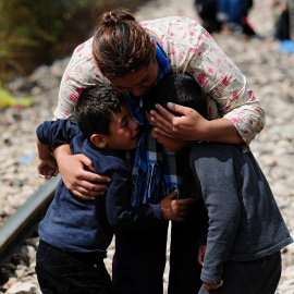 Una mujer abraza a dos niños después de cruzar la frontera de Grecia a Macedonia.- OGNEN TEOFILOVSKI (REUTERS)