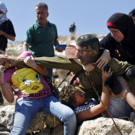 Palestinos se pelean con un soldado israelí en su intento de evitar que la detención de un niño, durante una protesta contra los asentamientos judíos en la aldea cisjordana de Nabi Saleh, cerca de Ramallah. REUTERS