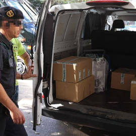 Agentes de la Guardia Civil retiran el material recogido durante el registro efectuado en la sede de la fundación CatDem de CDC./ EFE