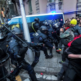 Miembros de los Mossos d´Esquadra impiden el paso de manifestantes en las inmediaciones de la Delegación del Gobierno en Cataluña, donde centenares de independentistas tratan de desbordar el cordón policial en protesta por la detención del 