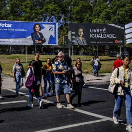01/10/2019 - Personas cruzan una calle en Portugal ante pancartas electorales. / AFP - PATRICIA DE MELO MOREIRA