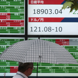 Un hombre camina junto a una pantalla que muestra información bursátil en Tokio. EFE/Kimimasa Mayama