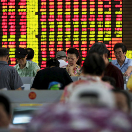 Varios inversores consultan la marcha de las bolsas en los ordenadores de una firma de brokers en Shanghai (China).. REUTERS/Aly Song