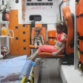 Omran Daqneesh, de cinco años, junto a su hermana en la ambulancia tras ser rescatados de un bombardeo en Alepo. REUTERS