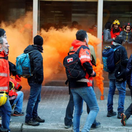 Diversos bombers llencen petards i bengales a l'entrada de la conselleria d'Interior on s'han dirigit desenes de treballadors que es manifesten des de la primera hora del matí pel centre de Barcelona davant la "manca de resposta" a les dema