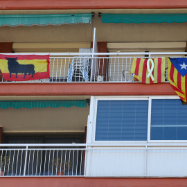 Banderas de España (con el toro de Osborne), la senyera (con el lazo amarillo por los políticos encarcelados), y la estelada, en unos balcones en Barcelona.. REUTERS/Albert Gea