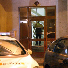 Un policía en el edificio donde se ha encontrado una mujer muerta con signos de violencia en Reus. (JAUME SELLART | EFE)