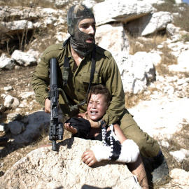 Un soldado israelí detiene a un niño palestino durante una protesta en Ramala. - REUTERS
