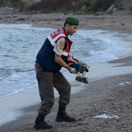 Un agente de la gendarmería turca lleva el cuerpo de un niño que formaba parte del grupo de refugiados sirios que se han ahogado intentando llegar a la isla de Kos. REUTERS/Nilufer Demir