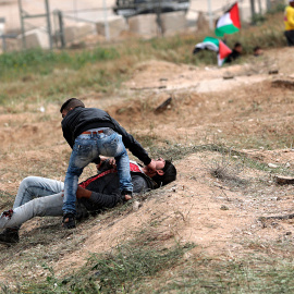 Un palestino ayuda a un compañero herido durante los enfrentamientos con soldados israelíes en el este de Beit Hanun, norte de la Franja de Gaza.-  EFE/Mohammed Saber