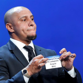 El ex jugador brasileño Roberto Carlos muestra la papeleta del Ludogorets Razgrad durante el sorteo de los emparejamientos de la fase de grupos de la Liga de Campeones. EFE/Sebastien Nogier