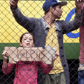 Refugiados piden ayuda en un andén de la estación ferroviaria de Bicske (Hungría). / HERBERT P. OCZEBET (EFE)