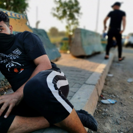 Un manifestante se refugia durante una de las protestas contra el Gobierno iraquí. (REUTERS/Thaier Al-Sudani)