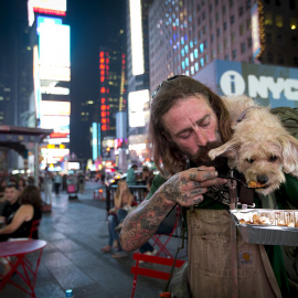 Un viajero da de comer a su perro en Times Square, Manhattan, Nueva York, 4 de septiembre de 2015. REUTERS/Carlo Allegri